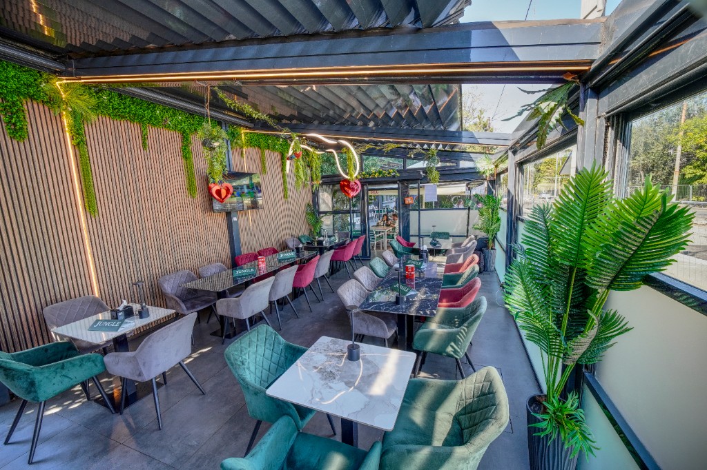 Terasă Jungle Bistro văzută de sus, mese de marmură și fotolii catifelate